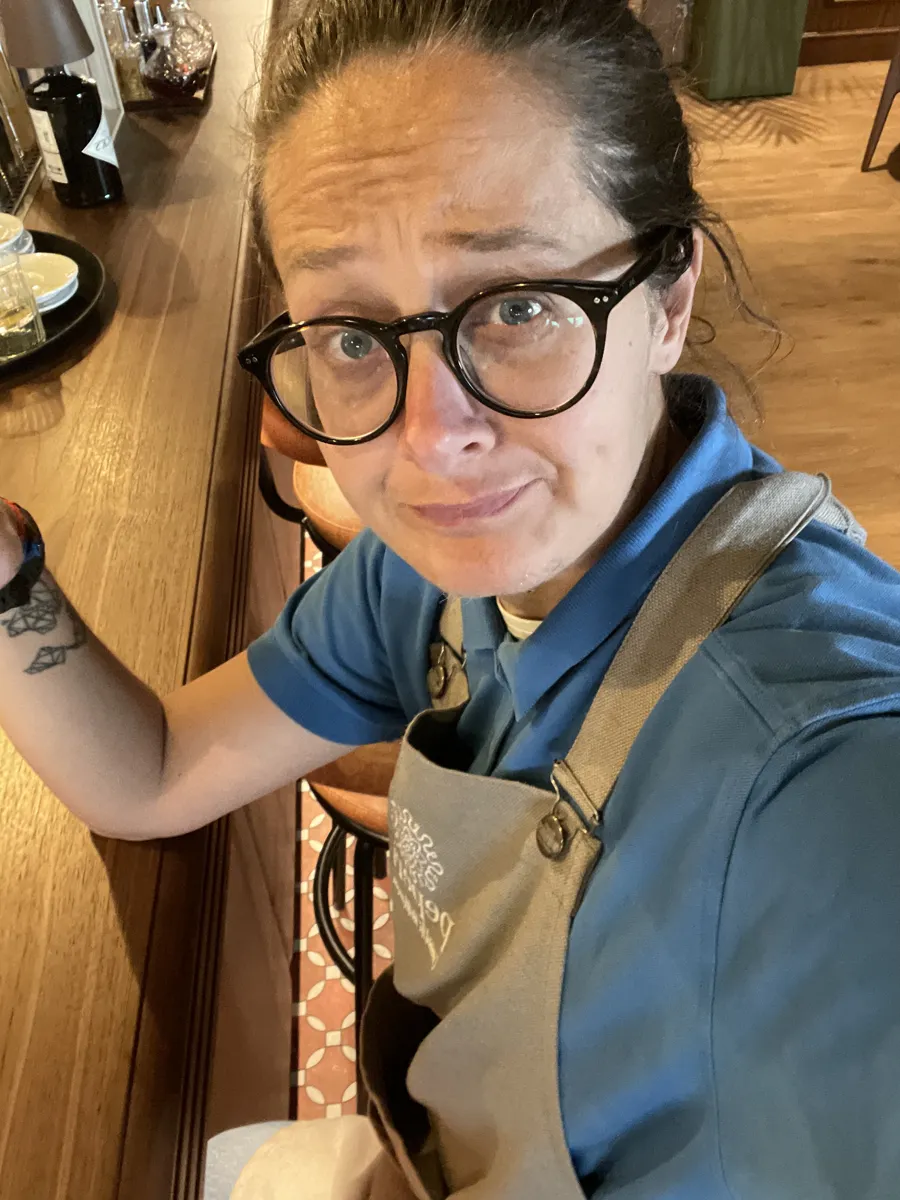 Ornella in sala, con polo azzurra e grembiule da cameriera
